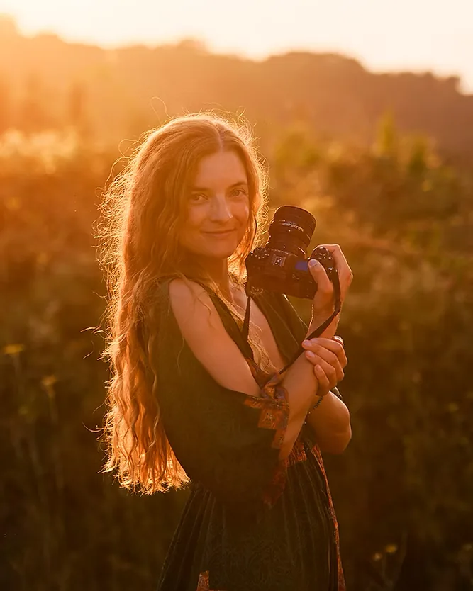 Elena, photographe, appareil en main au coucher du soleil