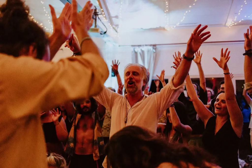 Phil chante, bras levés avec le groupe