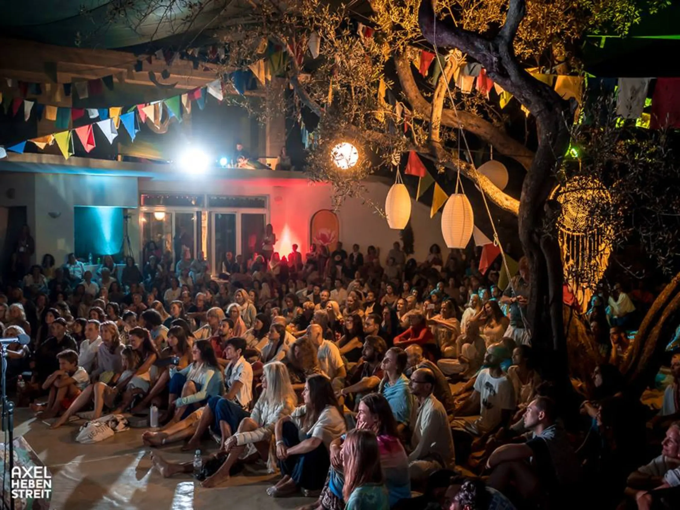 Public assis sous les arbres lors d'un concert du soir à Gayatri